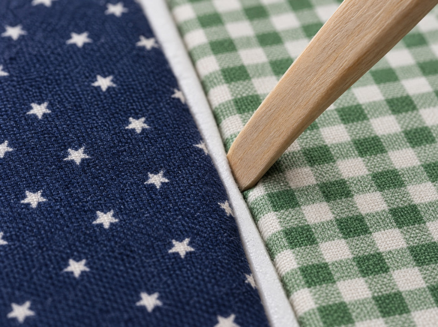Macro photo of two fabrics tucked into a cut in foam, no stitching